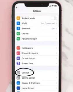 A smartphone screen showing the device settings menu, with the "General" option highlighted for iOS and "Apps" or "Application Manager" highlighted for Android.