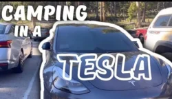 Tesla parked in a scenic camping location, with Camp Mode activated for a cozy and comfortable stay