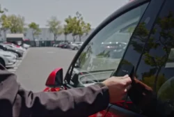 Valet using the Tesla key card to unlock the car by pressing it against the driver's side door pillar.